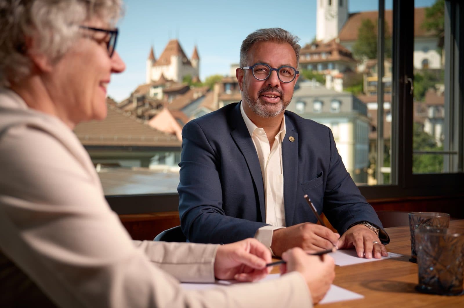 Nik Gugger im Gespräch mit einer Kundin, Schloss Thun im Hintergrund